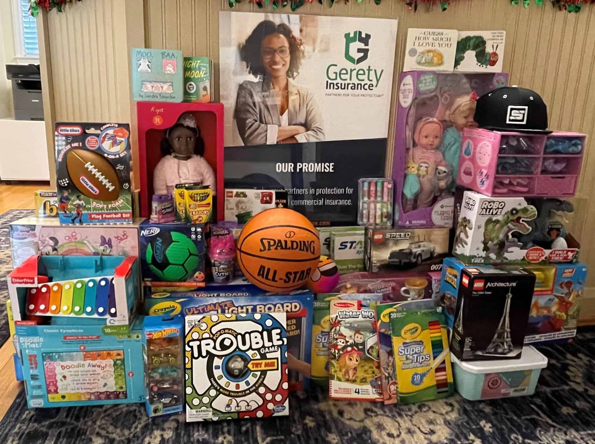 Assorted children's toys and games stacked with a basketball.