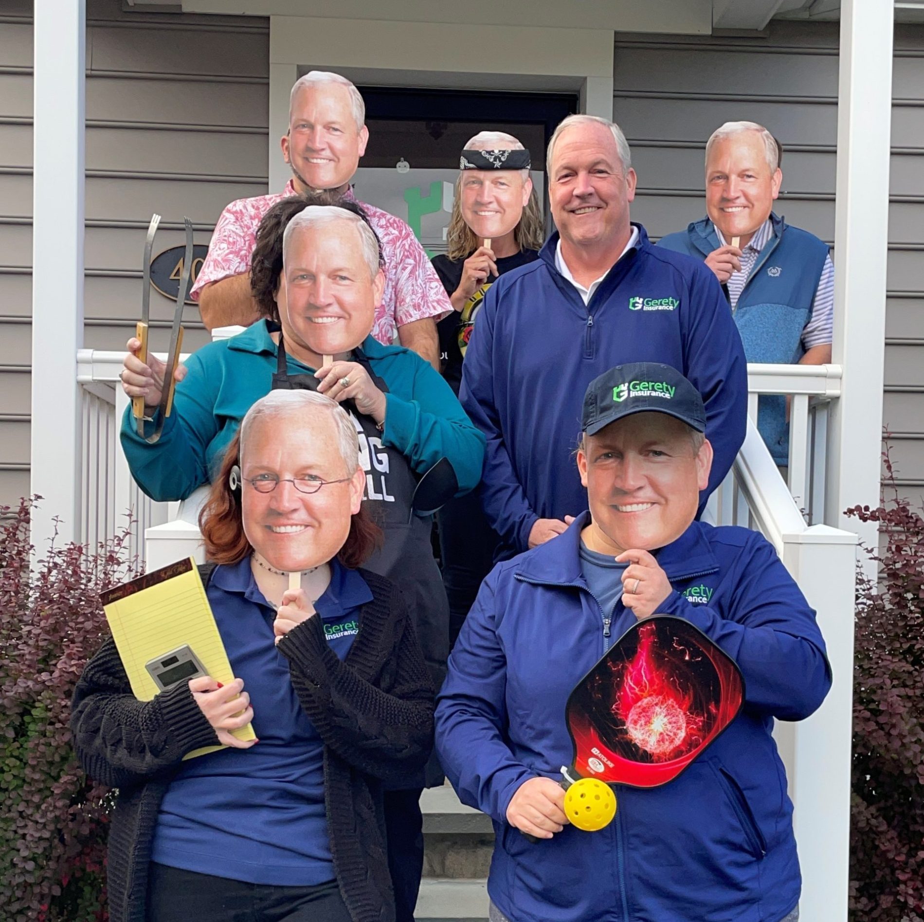 Group on porch wearing identical masks of Rick Gerety's face.
