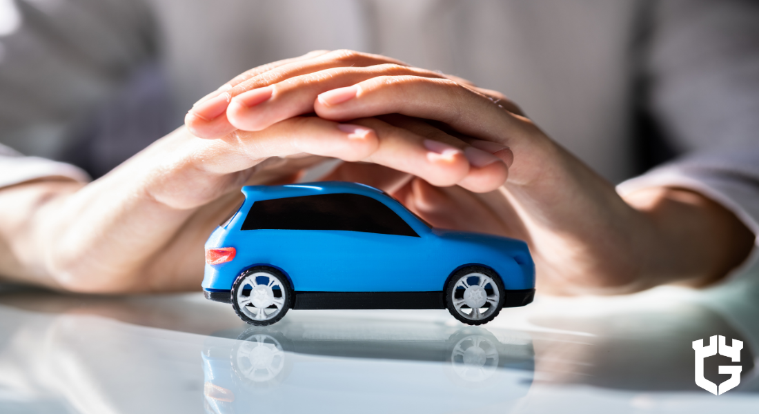 Hands shelter a small blue toy car