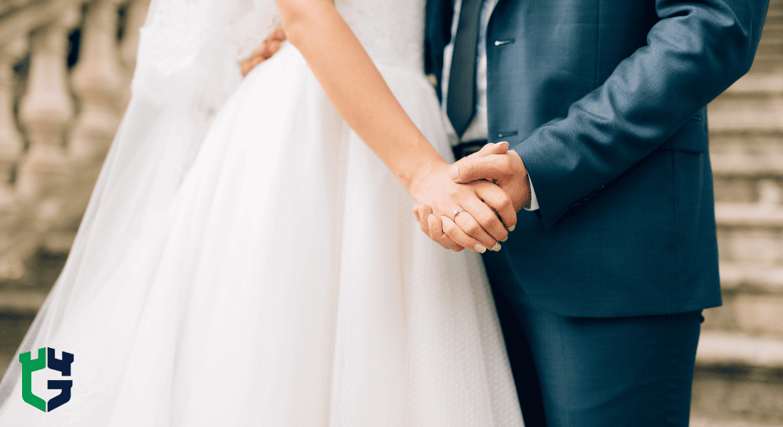 Bride and groom holding hands, showing wedding ring.