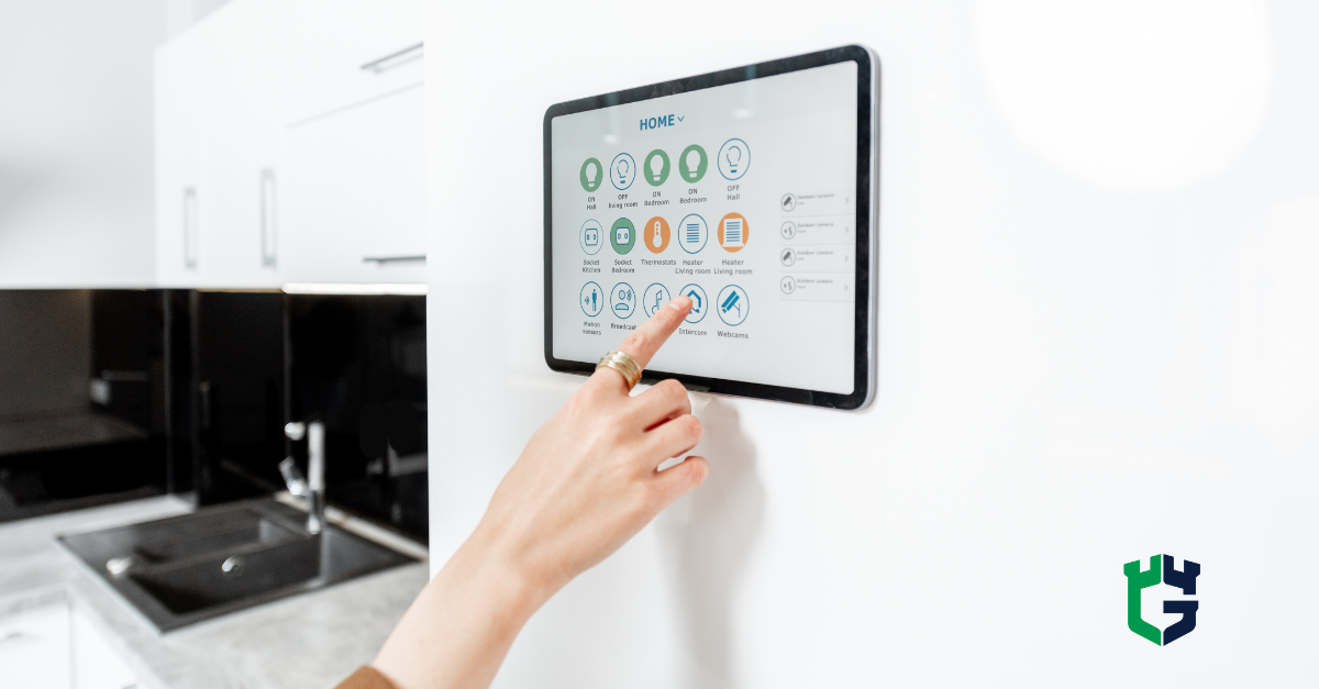 Hand touching wall-mounted smart home control tablet in kitchen