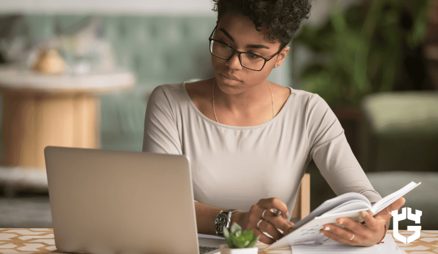 Young woman with glasses studying at a laptop