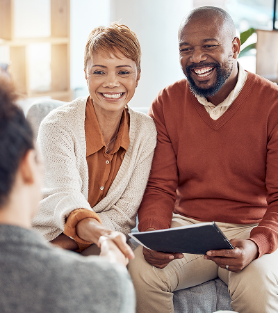Smiling couple shaking hands with insurance advisor, holding tablet