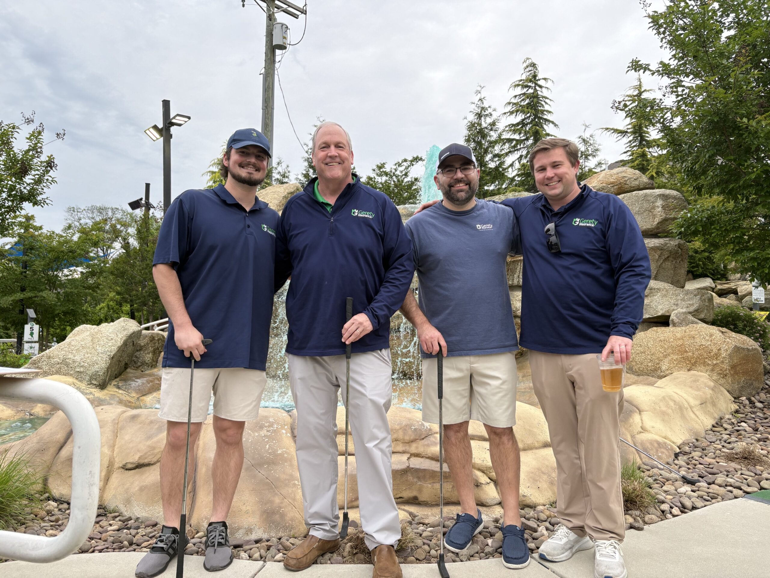 Rick Gerety posing outside with three Gerety Insurance employees