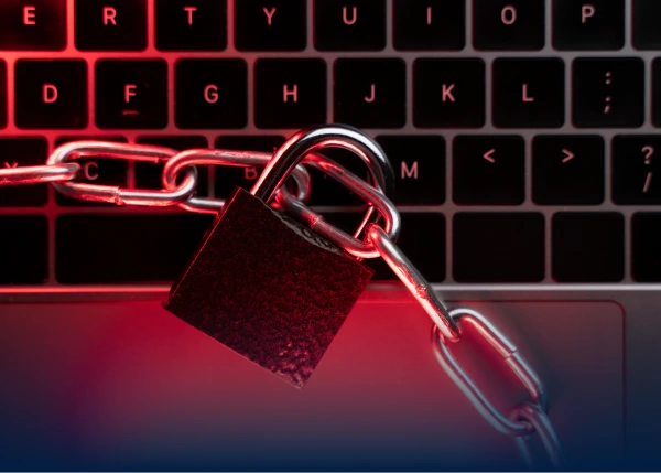 Padlock and chain locked over laptop keyboard in red light