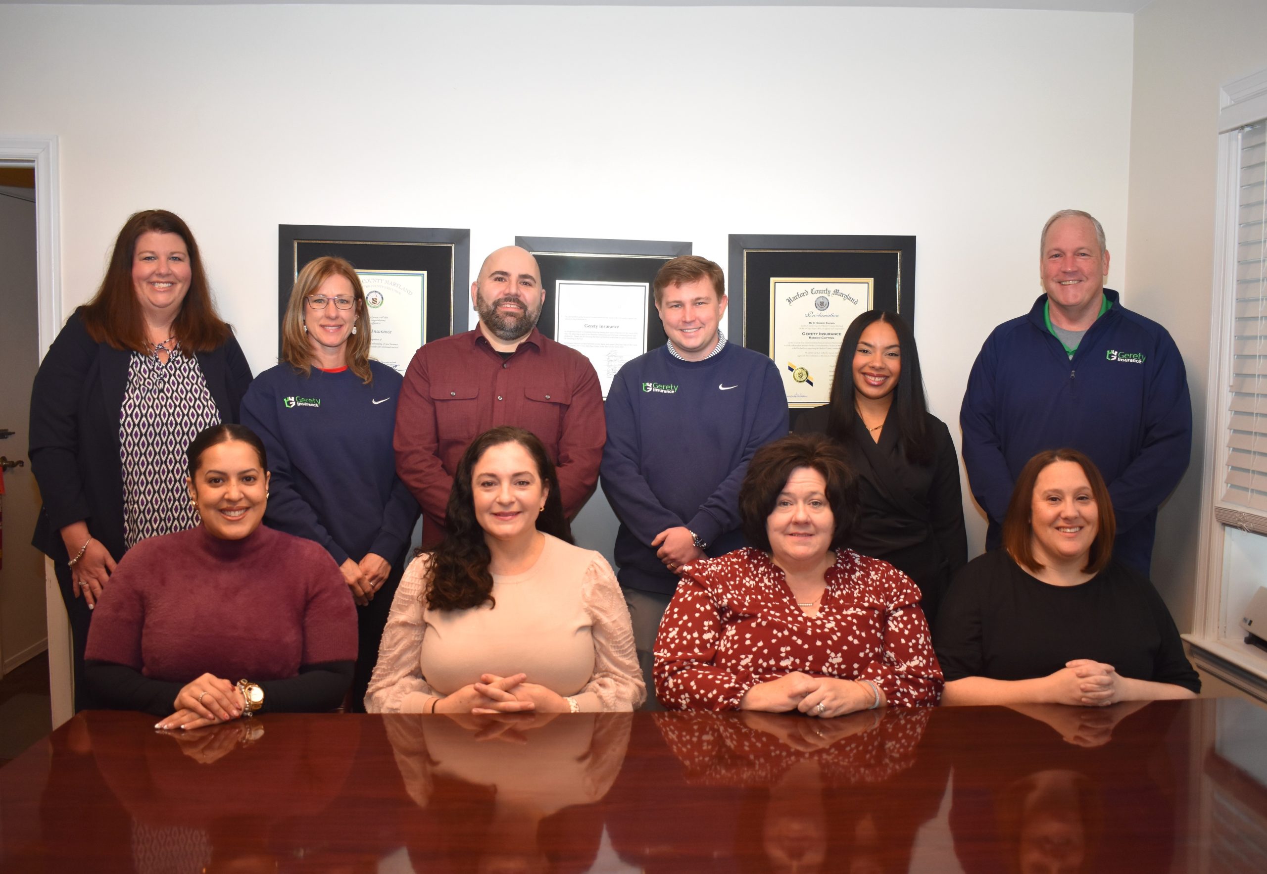 Smiling Gerety staff posed around a conference table