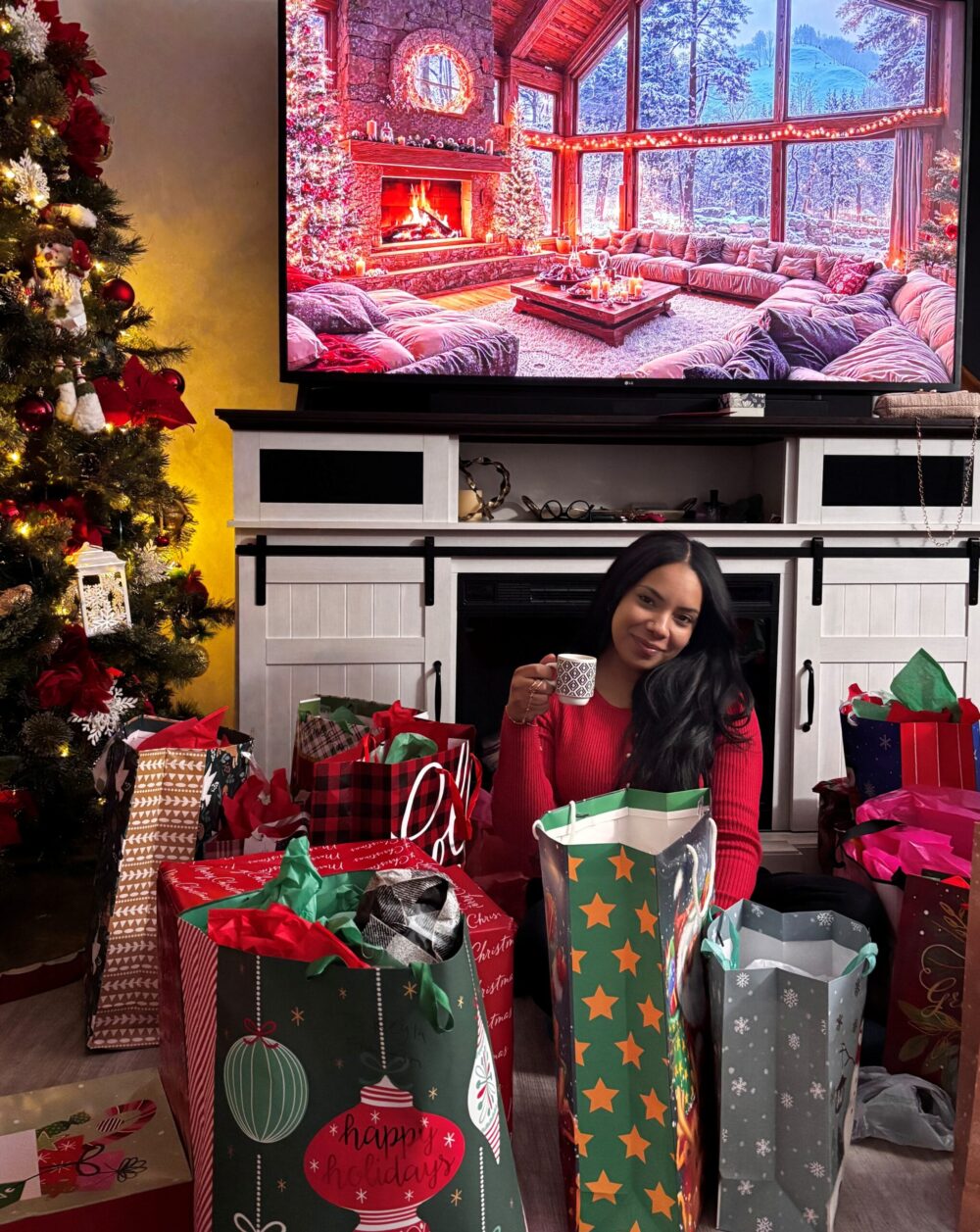 Keyla Perez sitting among Christmas gift bags in front of a decorated Christmas tree